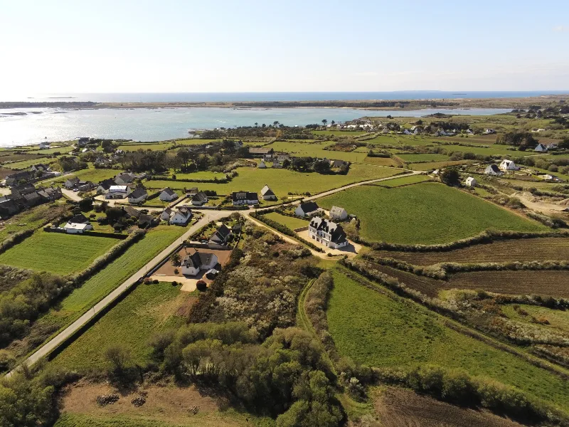 Vue aerienne du domaine dans la campagne bretonne avec littoral et mer en arriere-plan