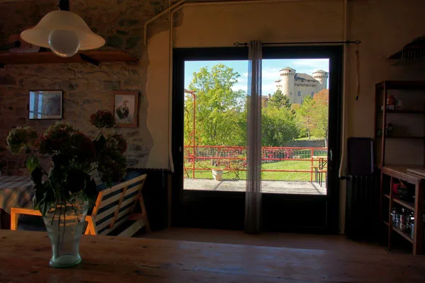 Pièce à vivre avec baie vitrée donnant sur le château et bouquet de fleurs