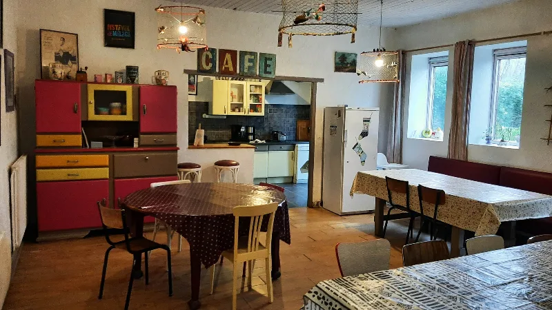 Cuisine rétro avec meubles vintage rouges, enseigne CAFÉ et tables conviviales