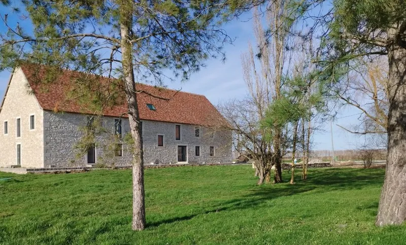 Façade en pierre du Grand Breuil avec sa grande terrasse et son jardin