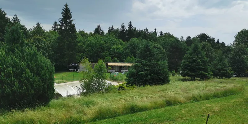 Vue d'ensemble du site avec les chalets et la prairie fleurie à Sérandon