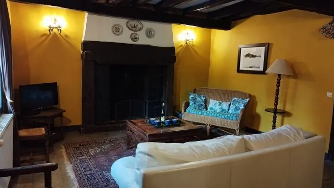 Intérieur d'un des gîtes avec poutres apparentes et décoration soignée