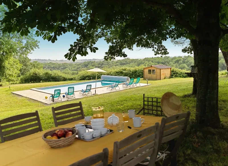Le parc et la piscine du domaine, table dressée à l'ombre des arbres