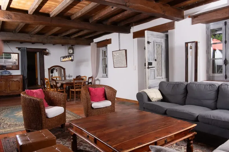 Le grand salon de 55 m2 avec sa cheminée et ses poutres apparentes
