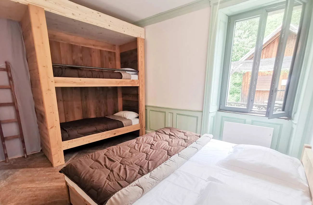 Chambre quadruple confortable dans l'auberge, avec lits et rangements pour les séjours de groupe