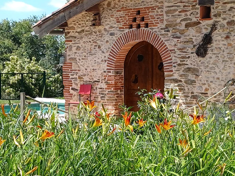 Espaces extérieurs de La Balagane en été avec jardins verdoyants dans le Tarn