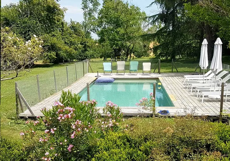 Plage de la piscine avec transats et vue sur la campagne gasconne