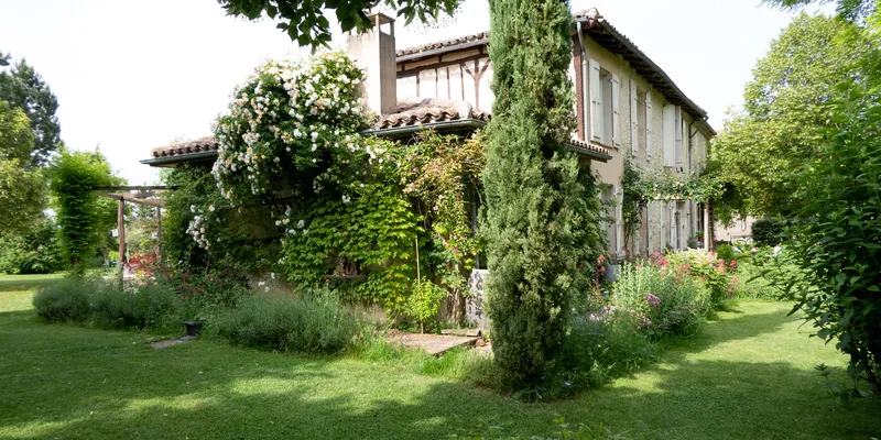 Façade en pierre gasconne du XVIIIe siècle avec volets bleus