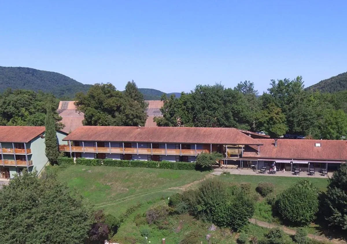 Gîte de groupe Le Bois Perché à Aspet — Vue aérienne d'un long bâtiment avec balcons en bois et toit rouge en montagne, capacité 174 personnes