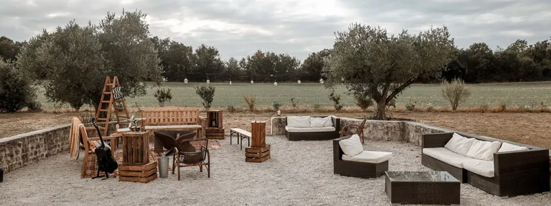 Terrasse ombragée de l'abbaye avec mobilier de jardin et vue sur le parc