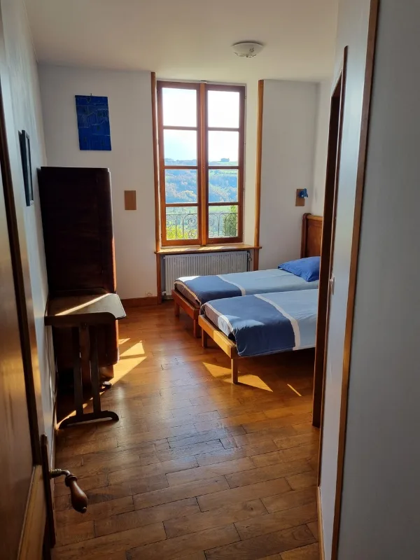 Chambre familiale colorée avec plusieurs lits simples, parquet en bois