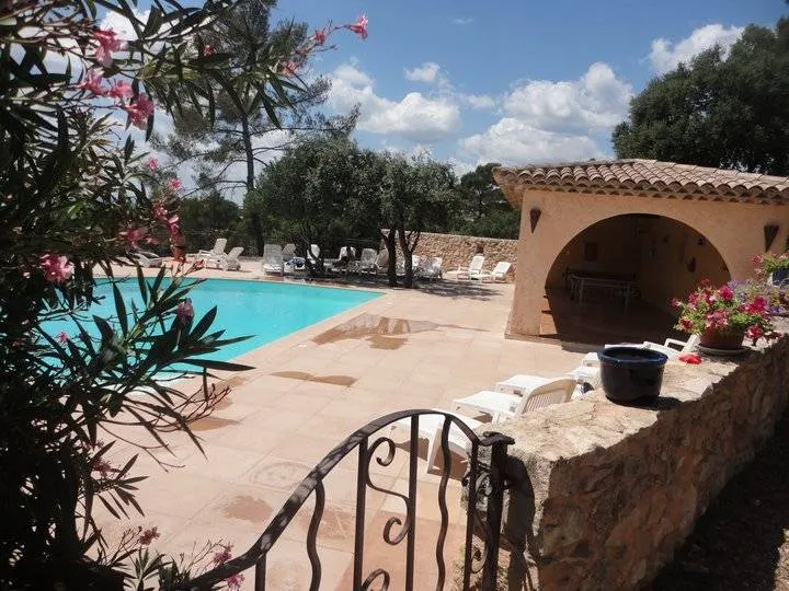 Piscine provençale avec pergola en pierre, lauriers roses et oliviers autour