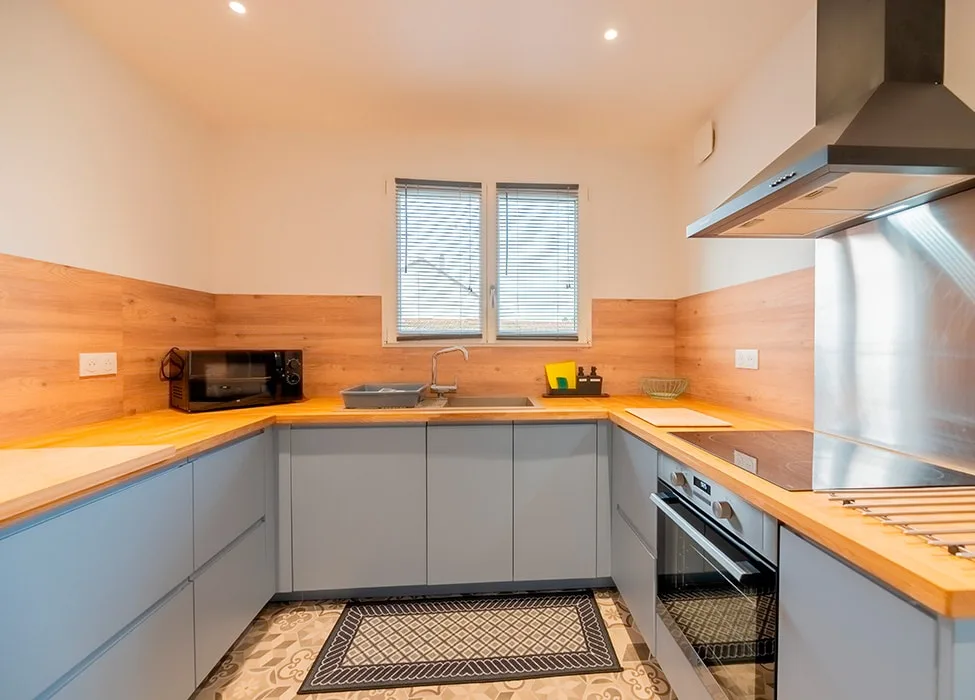 Cuisine équipée moderne avec plan de travail en bois et hotte design
