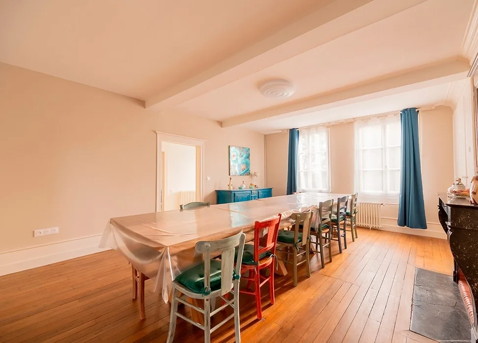 Grande salle à manger avec longue table en bois pour tout le groupe