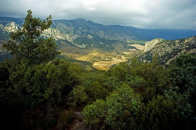Vue panoramique sur vallée entre falaises de garrigue sous ciel d'orage