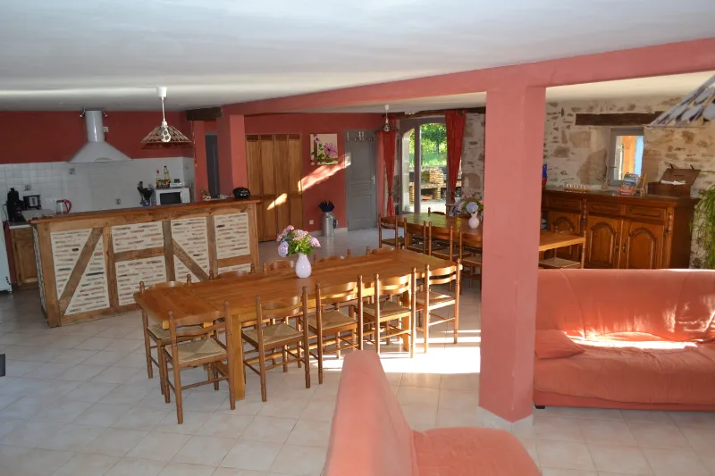 Grande cuisine ouverte sur salle à manger avec longue table en bois pour le groupe