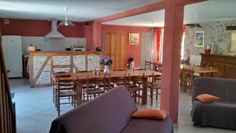 Terrasse ombragée sous pergola avec tables dressées pour les repas de groupe