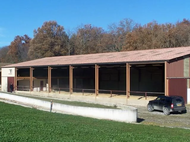Manège équestre couvert avec box et grand espace de travail pour les chevaux