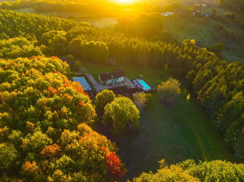 Grand séjour design sous verrière avec canapés et vue panoramique sur la campagne