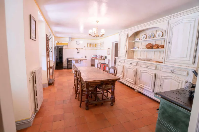 Cuisine et salle à manger rustique au sol en tomettes avec buffet ancien
