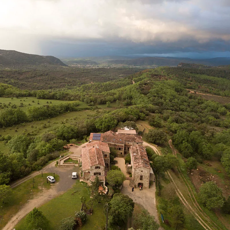 Vue aérienne du domaine en Ardèche avec bâtisses en pierre nichées dans la campagne verdoyante