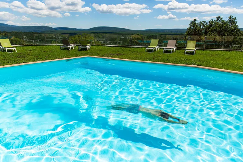 Piscine extérieure entourée de pelouse avec vue panoramique sur les Gorges de l'Ardèche