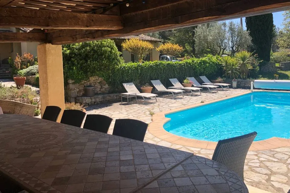 Gîte de groupe Mas Les Heures Bleues à Lorgues — Piscine extérieure entourée de transats et terrasse en pierre, vue sur les oliviers, capacité 14 personnes