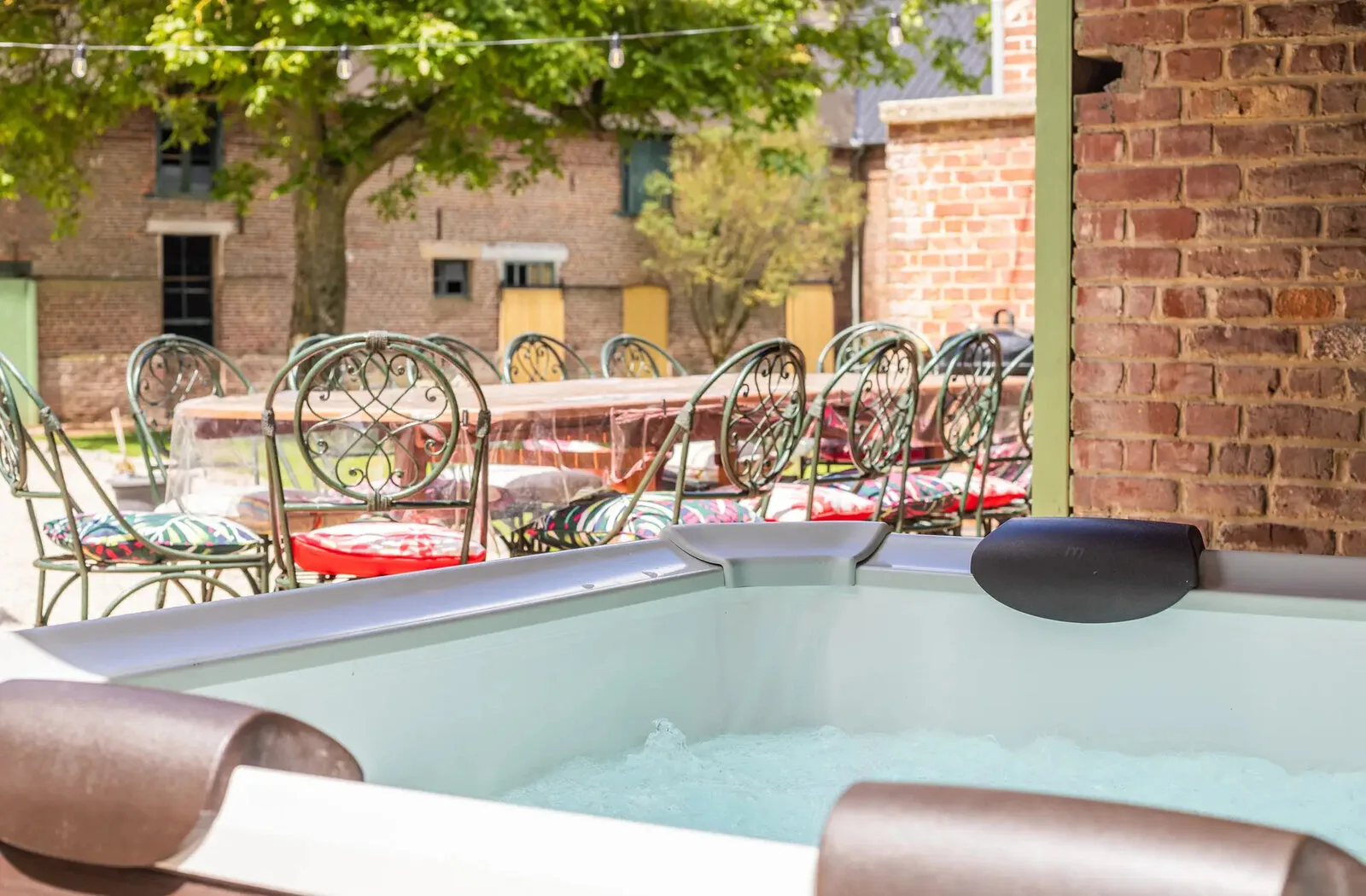Spa extérieur sous abri en bois avec vue sur la cour intérieure et mobilier de jardin