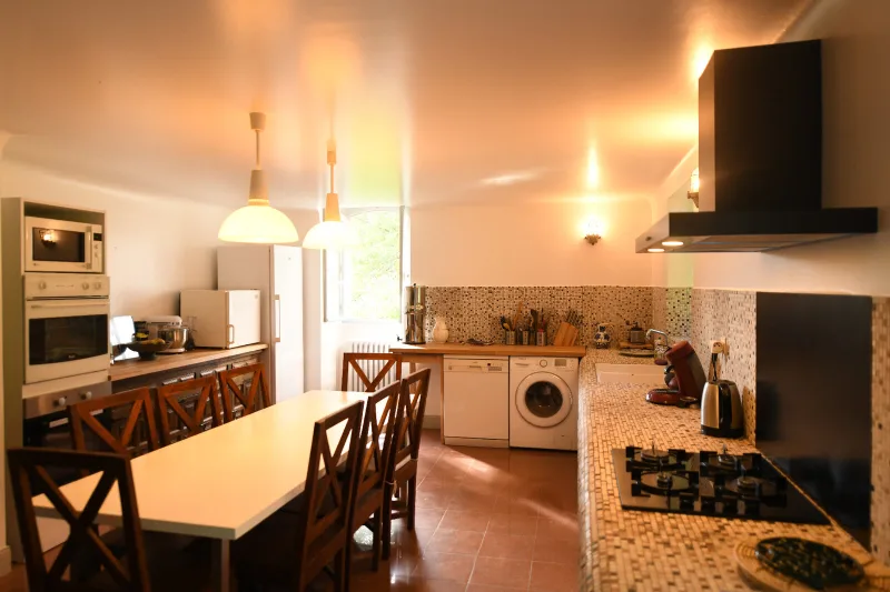Cuisine familiale entièrement équipée avec grande table pour les repas de groupe