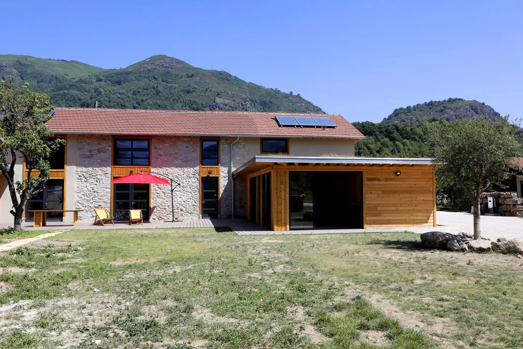 Gîte de groupe Le Grand Gîte d'Arignac à Arignac — Façade en pierre du domaine avec vue dégagée sur les sommets des Pyrénées, capacité 20 personnes