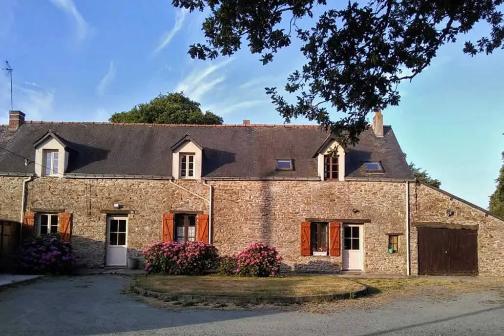 Gîte de groupe Grand Gîte du Menhir à Pontchâteau — Longère bretonne en pierre avec volets rouges, lucarnes et grand parking devant la maison, capacité 28 personnes