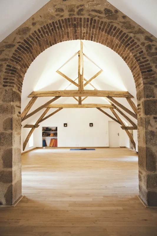 Salon ancien avec piano droit, tableau encadre et parquet en bois