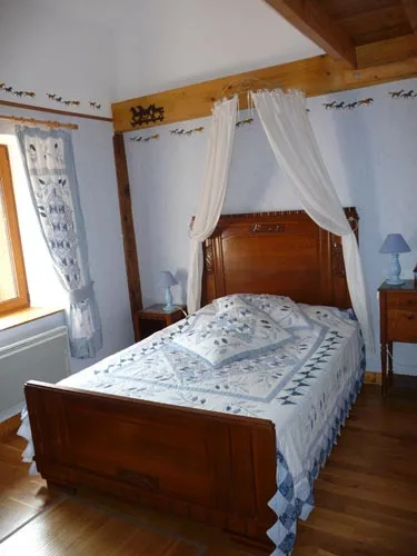Chambre ancienne avec lit à baldaquin en fer forgé et ciel de lit blanc