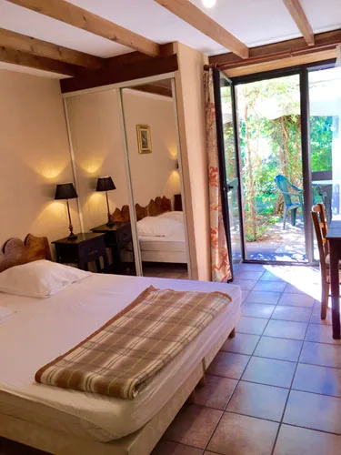 Chambre avec lit double, penderie miroir, ouvrant sur le jardin