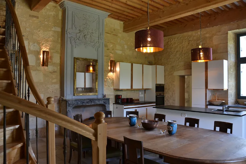 Cuisine équipée moderne avec grande table en bois et suspensions design