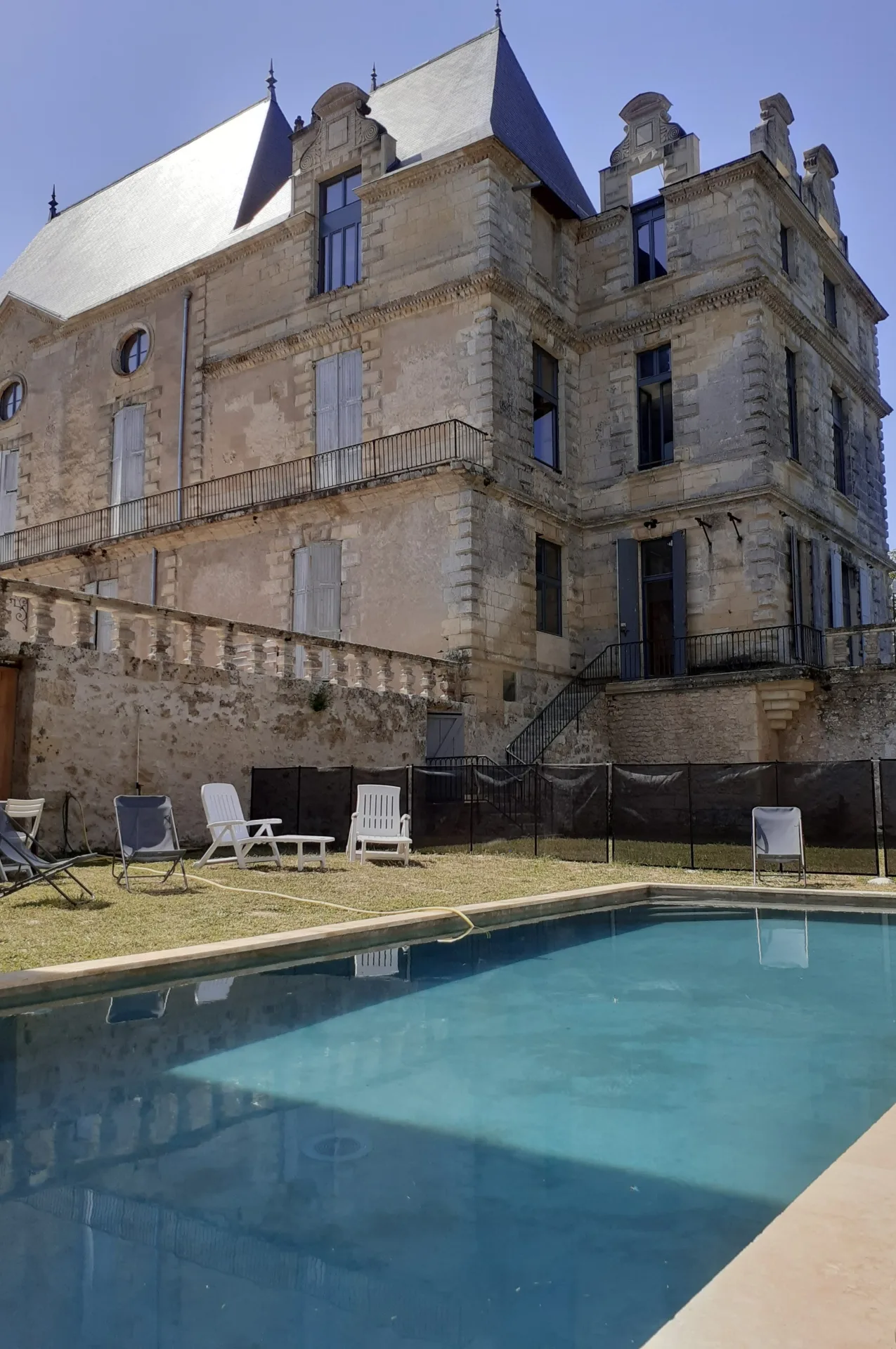 Gîte de groupe Château de Pile à Cours-de-Pile — Château de Pile vu depuis le jardin, avec sa piscine et sa tour en pierre dorée, capacité 15 personnes