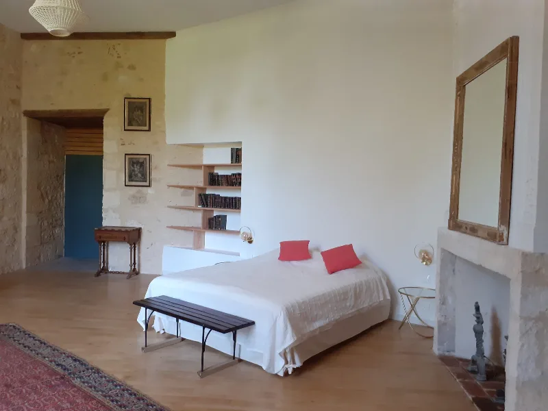 Chambre de la Reine avec lit double, cheminée en pierre et grand miroir ancien