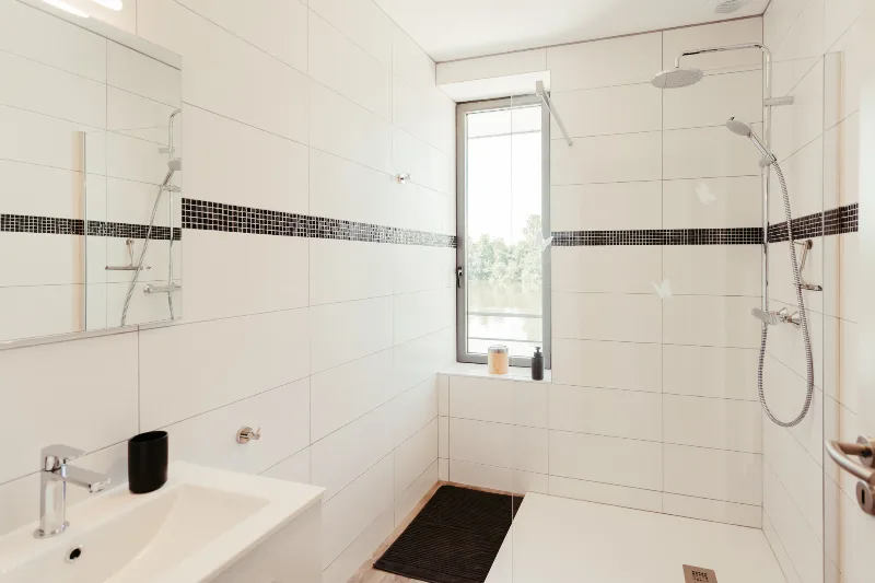 Salle de douche à l'italienne avec double vasque et fenêtre donnant sur la rivière