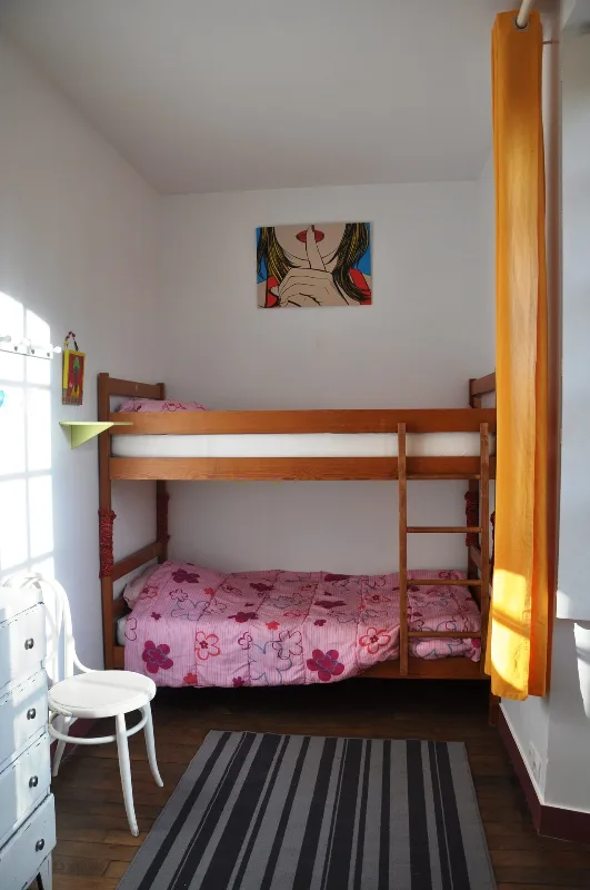 Chambre mansardée avec poutres en bois et lit double