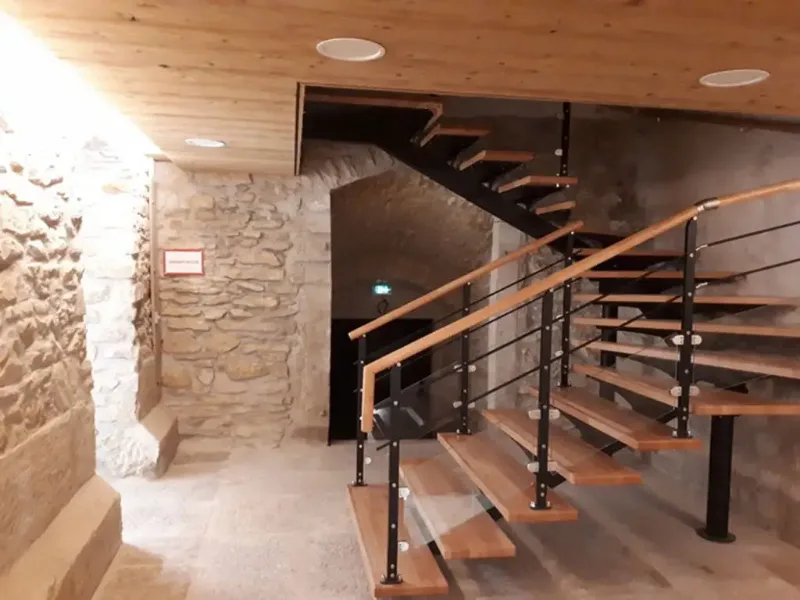 Escalier design menant à la cave voûtée en pierre du bâtiment