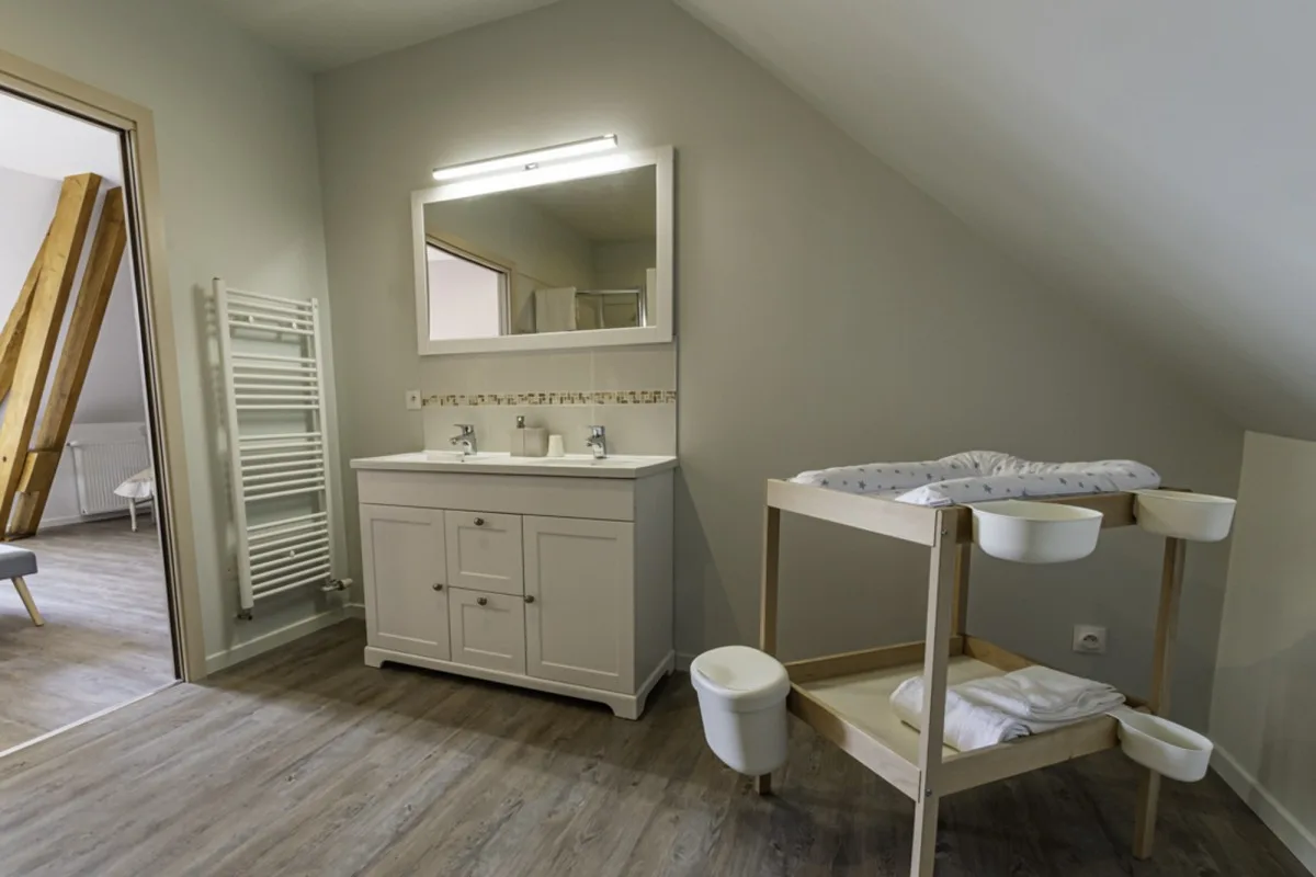 Salle de bains avec vasque double et table à langer