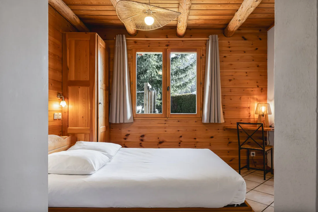 Chambre avec mezzanine et lit superposé accessible par échelle en bois