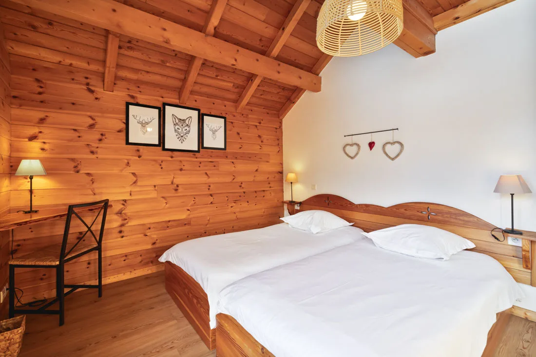 Chambre double avec tête de lit en bois et décoration montagne