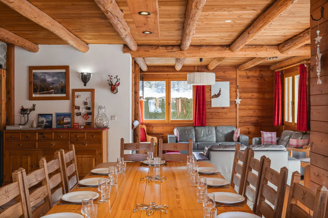 Salon avec cheminée, canapés en cuir et poutres apparentes