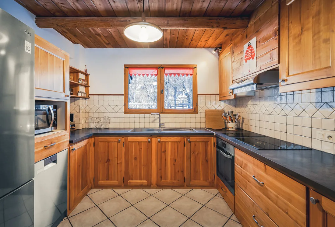 Cuisine équipée en bois avec four, plaques et micro-ondes