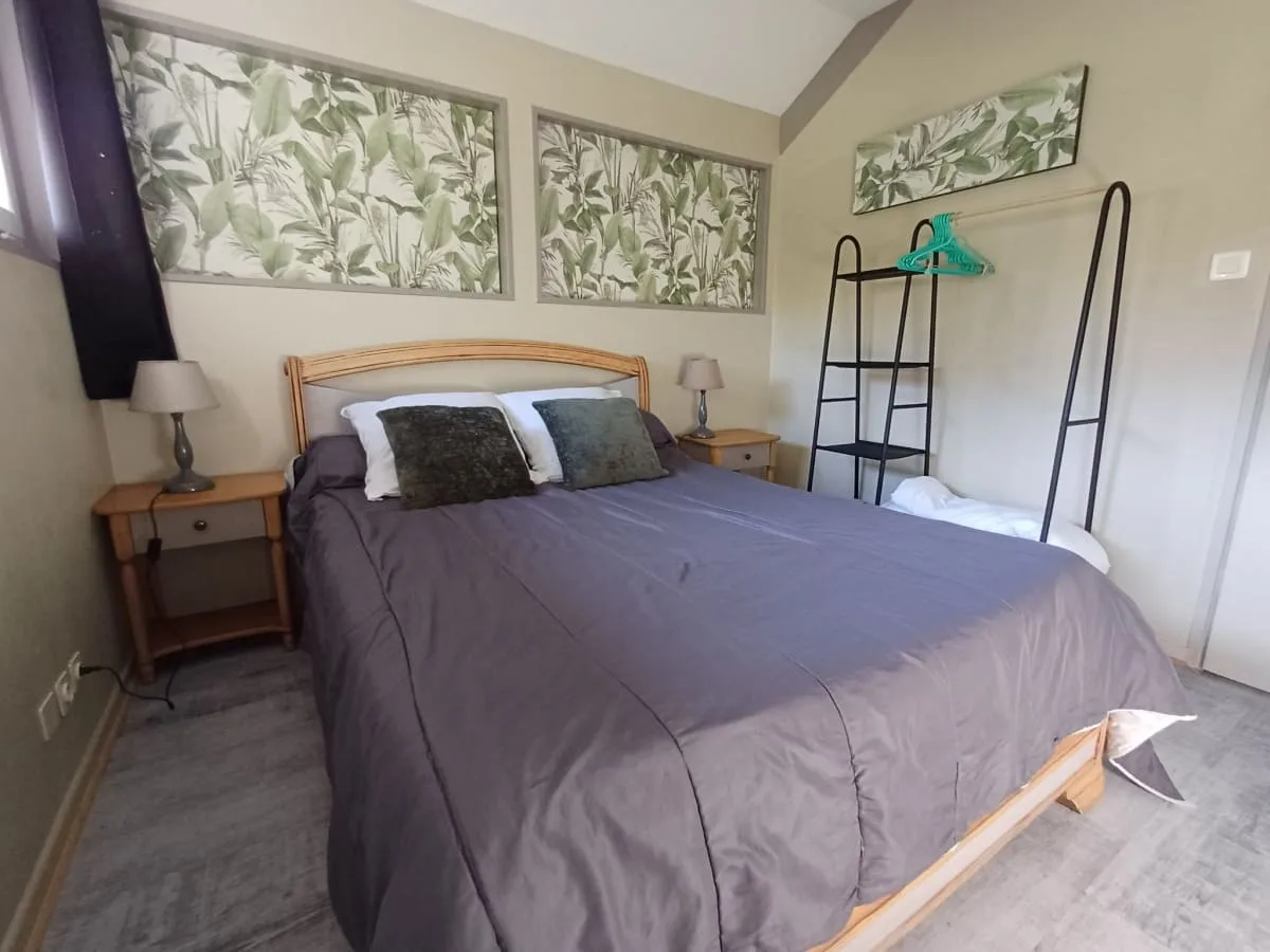 Chambre double du gîte avec parures à motifs floraux et mobilier en bois