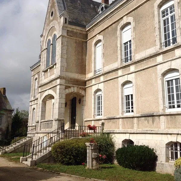 Façade en pierre du château avec perron d'entrée à double escalier