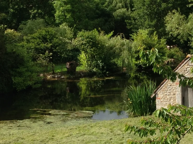 Vue sur la rivière l'Aigre depuis un pont en fer forgé vert