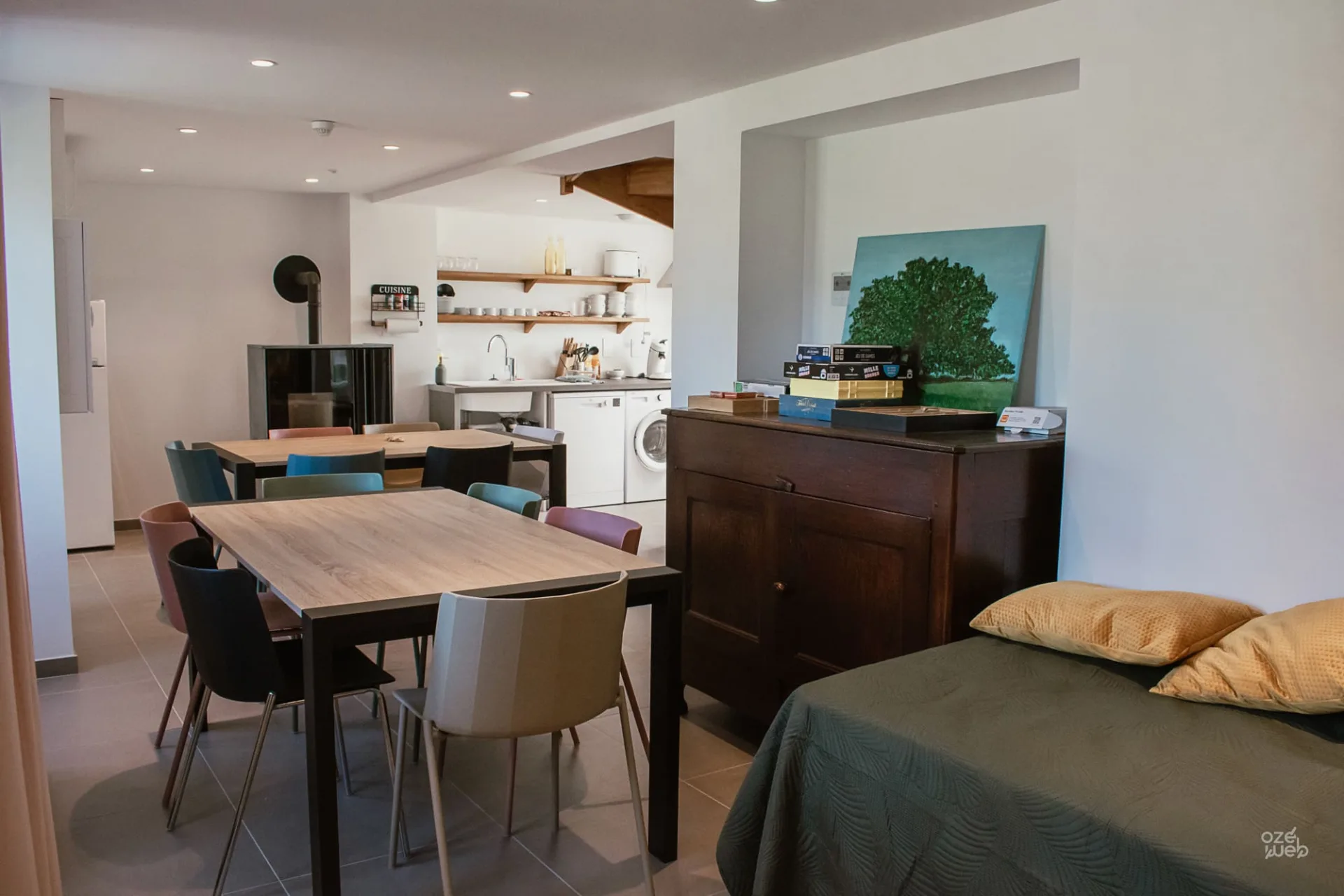 Espace de vie avec cuisine ouverte, coin jeux de société et canapé pour veillées en groupe