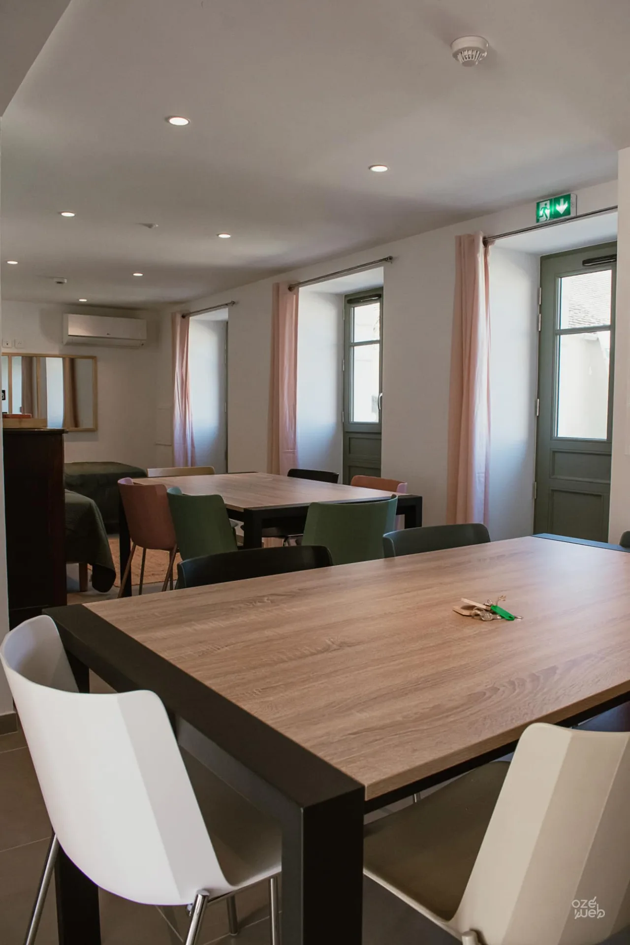 Salle à manger et coin salon du gîte Le Chêne Vert avec grandes tables en bois
